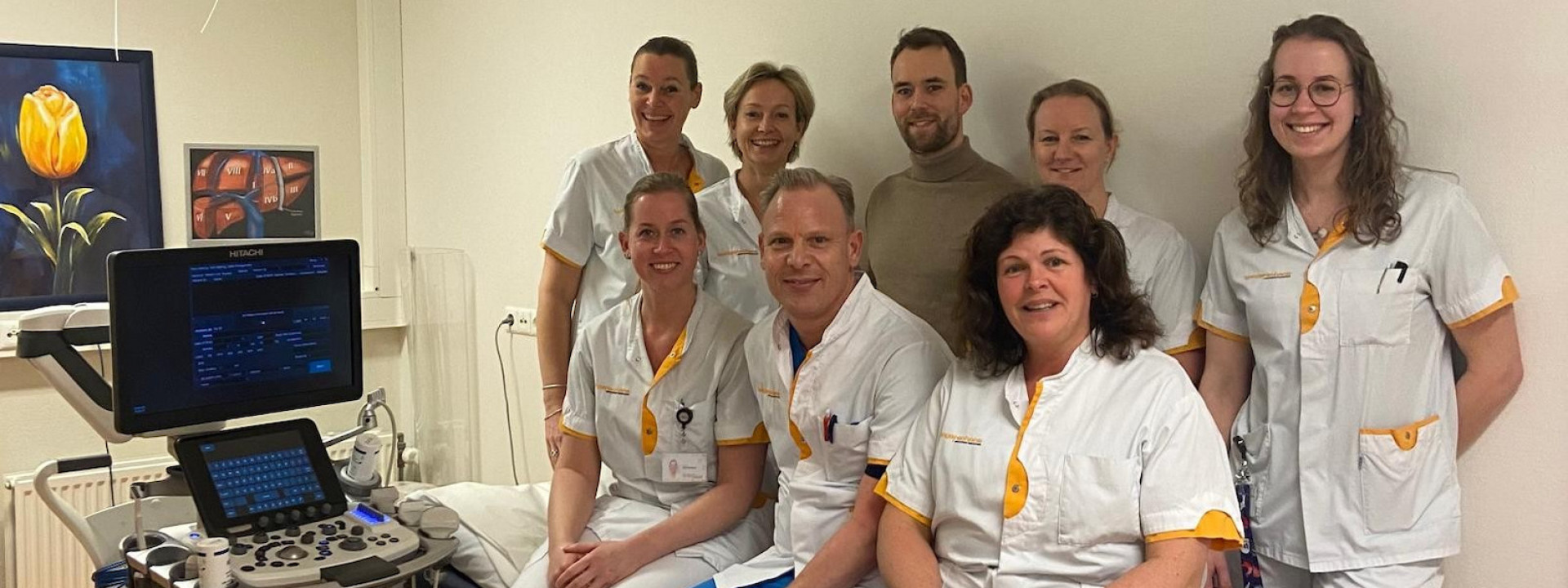 Een medisch team poseert met apparatuur in een ziekenhuisruimte.